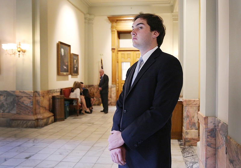 Colton Moore, 24, watches a ceremony happening in a lobby area of the Georgia State Capitol Thursday, March 29, 2018 in Atlanta, Ga. Moore, who is a candidate in the upcoming election for the District 1 House of Representatives seat in Georgia, was spending a few days at the Capitol to better prepare himself to take on the job should he win the election later this year. 