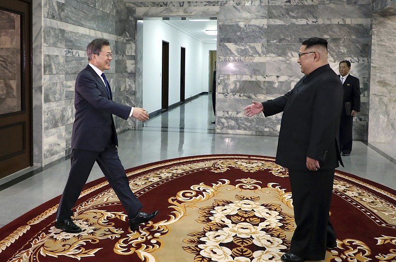 In this May 26, 2018 photo provided on May 27, 2018, by South Korea Presidential Blue House via Yonhap News Agency, North Korean leader Kim Jong Un, right, and South Korean President Moon Jae-in, left, reach out to shake hands before their meeting at the northern side of Panmunjom in North Korea.