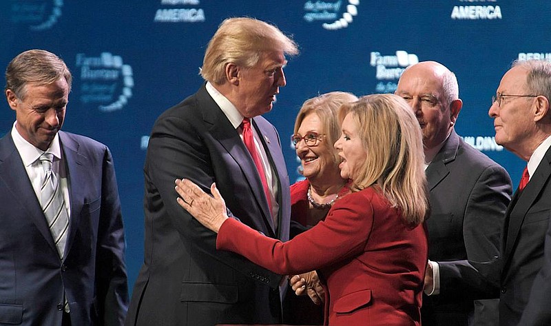 President Donald Trump shares the stage with Gov. Bill Haslam, Rep. Diane Black, Agriculture Secretary Sonny Perdue, Sen. Lamar Alexander and Rep. Marsha Blackburn and other lawmakers at Gaylord Opryland Resort & Convention Center on Jan. 8, 2018, in Nashville.