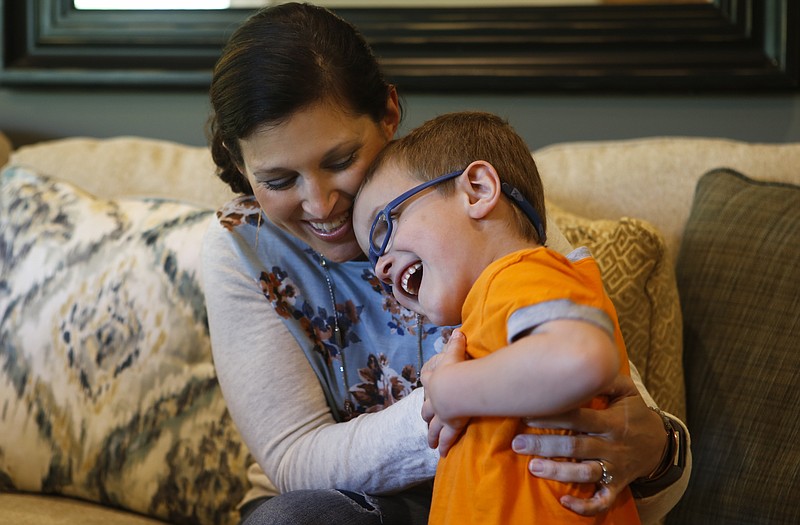 Laura Ledbetter hugs her 5-year-old son, Grayson, at their home in Ooltewah. Grayson has a rare nervous system disorder called Alexander disease. The family has set up the group Grayson's Ladder to raise support and awareness for the disease.