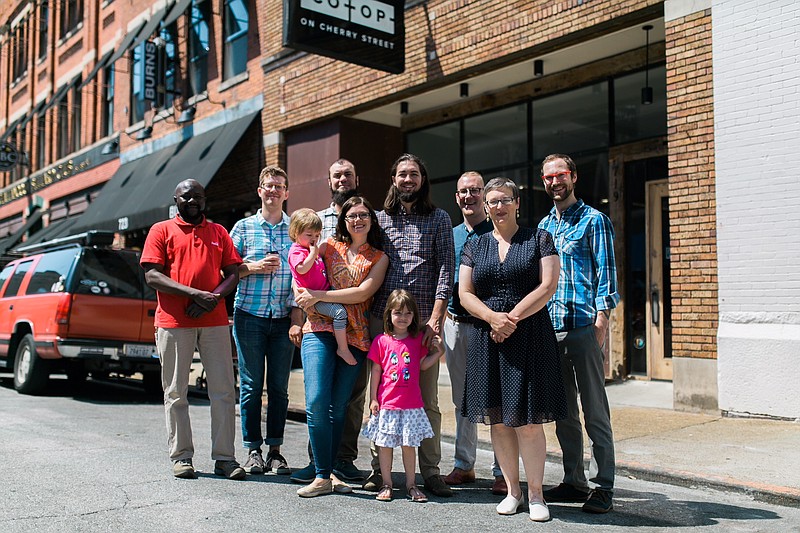 Tarig Idris, Luke Pigott, Matt Sears, Cherita and Michael Rice (with their children), Lauri Moyle, Jen Gregory and Mark Stahlwood, from left, stand in front of the space on Cherry Street where Sears and Rice plan to open The Mad Priest // Coffee & Cocktails this fall. (Contributed photo)