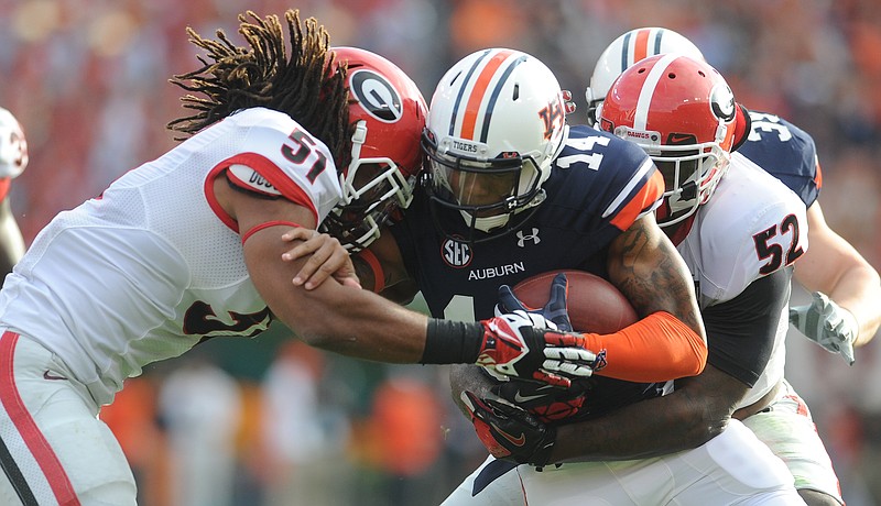 Auburn quarterback Nick Marshall is wrapped up by Georgia linebackers Ramik Wilson (51) and Amarlo Herrera (52) during their 2013 meeting. The Tigers and Bulldogs met in Auburn in 2012 and 2013 to help the SEC adjust to its new scheduling format following the additions of Missouri and Texas A&M.