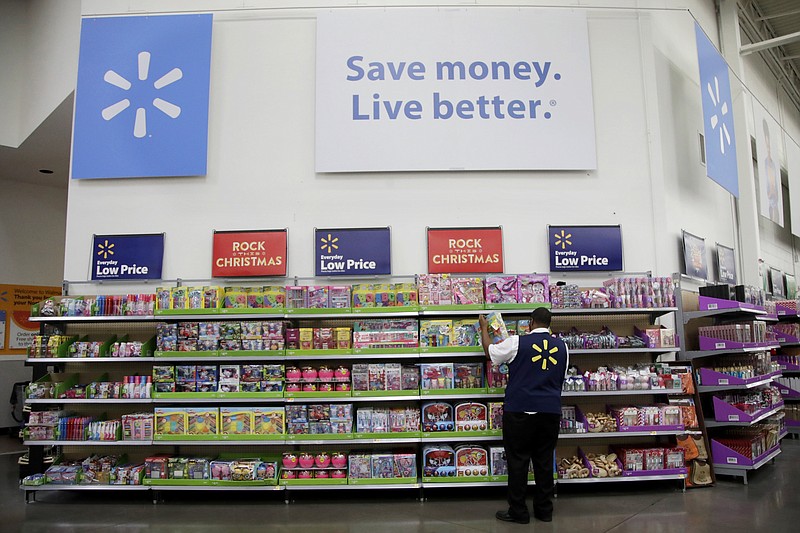 FILE- In this Nov. 9, 2017, file photo, a Walmart employee scans items while conducting an exercise during a Walmart Academy class session at the store in North Bergen, N.J. Walmart is offering its employees a new perk: affordable access to a college degree. America’s largest private employer, which in the past has helped its workers get their high school or equivalency degree, hopes the new benefit will help it recruit and retain higher quality entry-level employees in a tight U.S. labor market. (AP Photo/Julio Cortez, File)