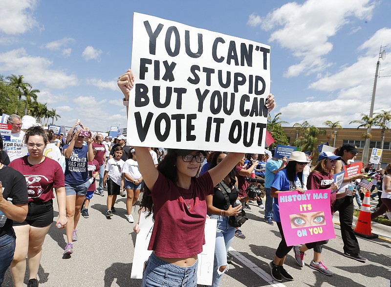 FILE - In this March 24, 2018 file photo, people take part in a "March For Our Lives" rally Saturday, March 24, 2018, in Parkland, Fla. TA new poll from The Associated Press-NORC Center for Public Affairs Research and MTV reveals a significant surge in the number of young people who feel politically empowered, a change that comes after a school shooting in Florida elevated the voices of high school students in American politics.  (AP Photo/Joe Skipper)