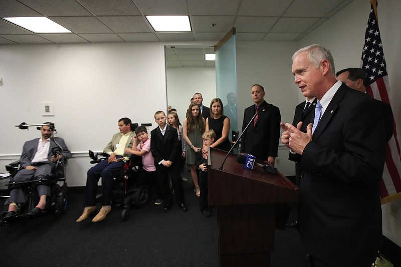 Sen. Ron Johnson, R-Wis., with ALS sufferers Frank Mongiello, from left, and Matthew Bellina, speaks during a news conference following the passage of the Right to Try Act at the Capitol in Washington, Tuesday, May 22, 2018. (AP Photo/Manuel Balce Ceneta)