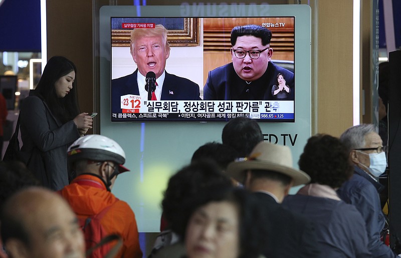 People watch a TV screen showing images of U.S. President Donald Trump, left, and North Korean leader Kim Jong Un during a news program at the Seoul Railway Station in Seoul, South Korea, Tuesday, May 29, 2018. A team of American diplomats involved in preparatory discussions with North Korea ahead of a potential summit between Trump and Kim left a hotel in Seoul on Tuesday amid speculation that they are resuming the talks. The signs read: "Working-level talks." (AP Photo/Ahn Young-joon)