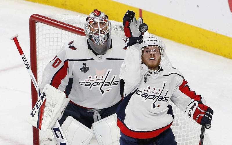 Washington Capitals defenseman John Carlson, right, knocks the puck away as goaltender Braden Holtby watches as time runs out in Game 2 of the team's NHL hockey Stanley Cup Finals against the Vegas Golden Knights on Wednesday, May 30, 2018, in Las Vegas. The Capitals won 3-2. (AP Photo/Ross D. Franklin)
