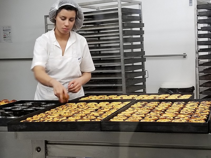A worker prepares pastel de nata, an egg tart pastry, at the cafe Pastéis de Belem, which opened in 1837. (Contributed Photo by Patti Smith)