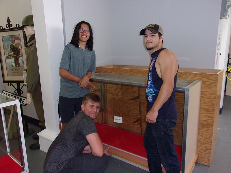 Performance Learning Center students help unload and move five display cabinets into the 6th Cavalry Museum.