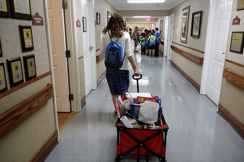 Teacher Beth Wilson wheels a cart of teaching supplies into Life Care Center of Red Bank on Tuesday, May 15, 2018, in Red Bank, Tenn. Wilson takes her class for active learning activities at the senior care facility.