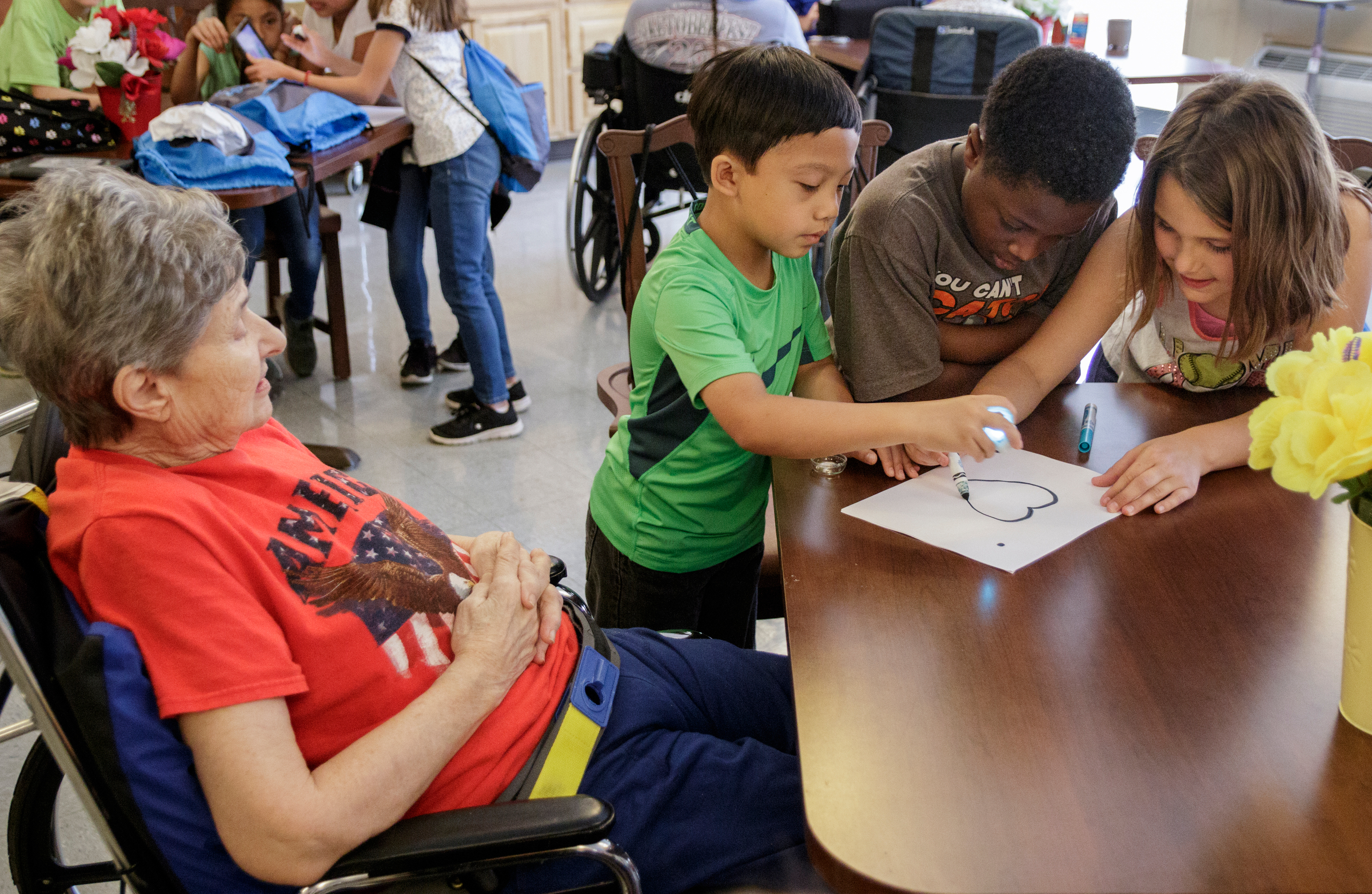 4th graders Taylor Hurst, right, Aslan Goines, center, and Calen Singgo show Bobbie Blackshear, left, how an ozobot works at Life Care Center of Red Bank on Tuesday, May 15, 2018, in Red Bank, Tenn. Teacher Beth Wilson takes her class for active learning activities at the senior care facility.