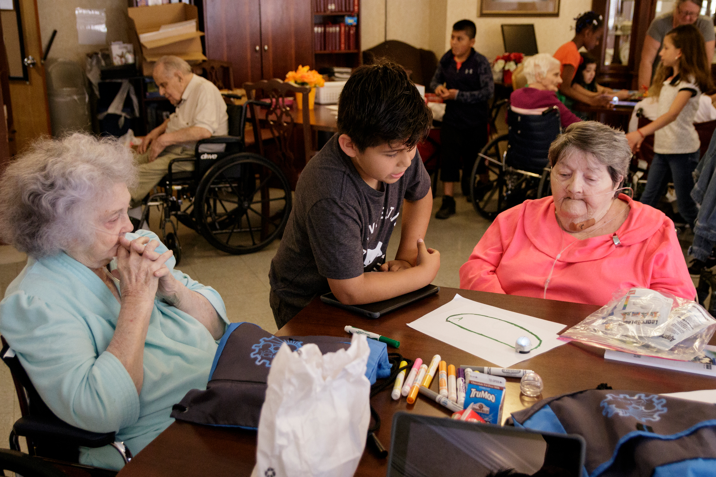 4th grader Joel Garcia, center, shows Delma Rea Stewart, left, and Julia Graham how an ozobot works at Life Care Center of Red Bank on Tuesday, May 15, 2018, in Red Bank, Tenn. Teacher Beth Wilson takes her class for active learning activities at the senior care facility.