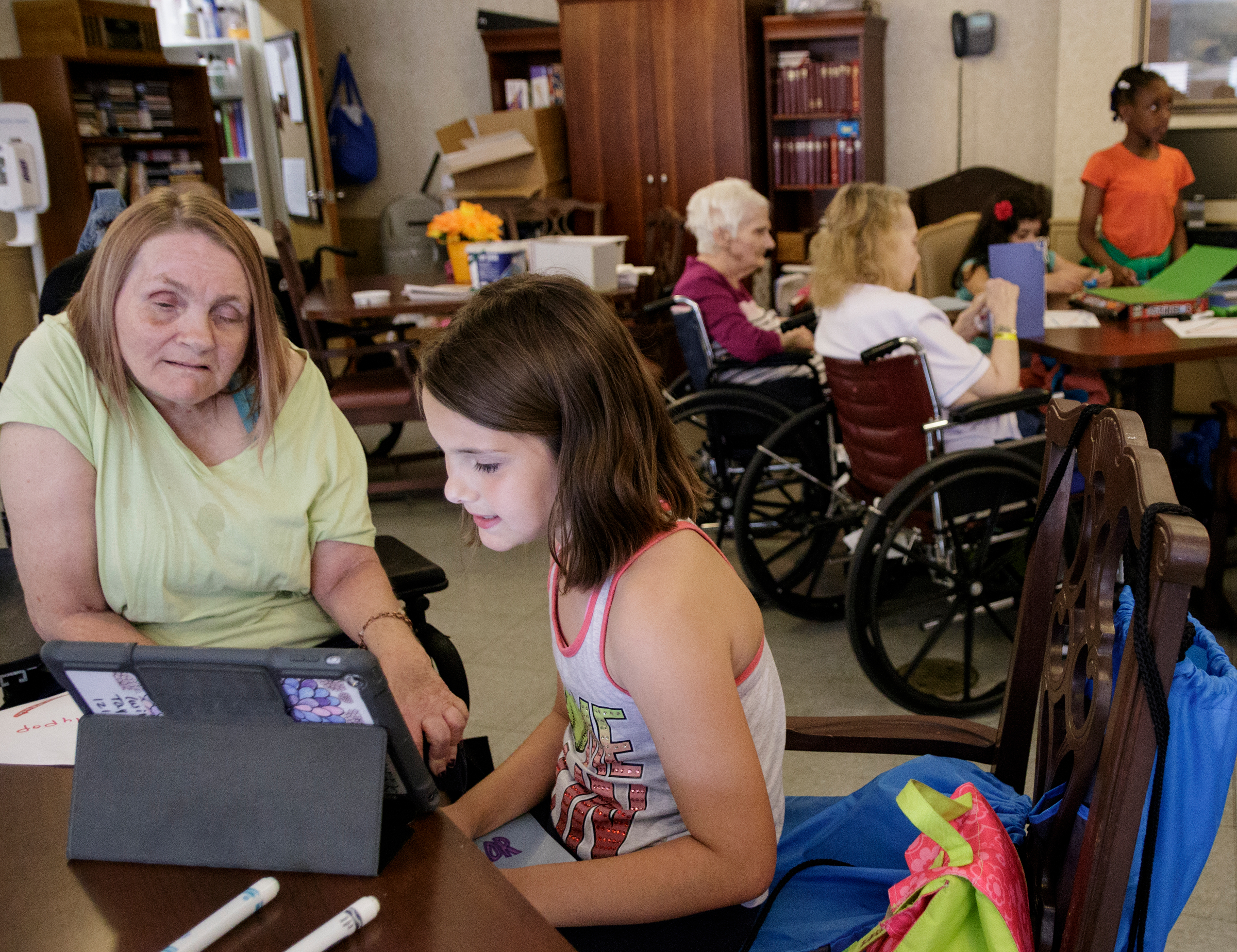 4th grader Taylor Hurst reads to Donna Owens, left, at Life Care Center of Red Bank on Tuesday, May 15, 2018, in Red Bank, Tenn. Teacher Beth Wilson takes her class for active learning activities at the senior care facility.