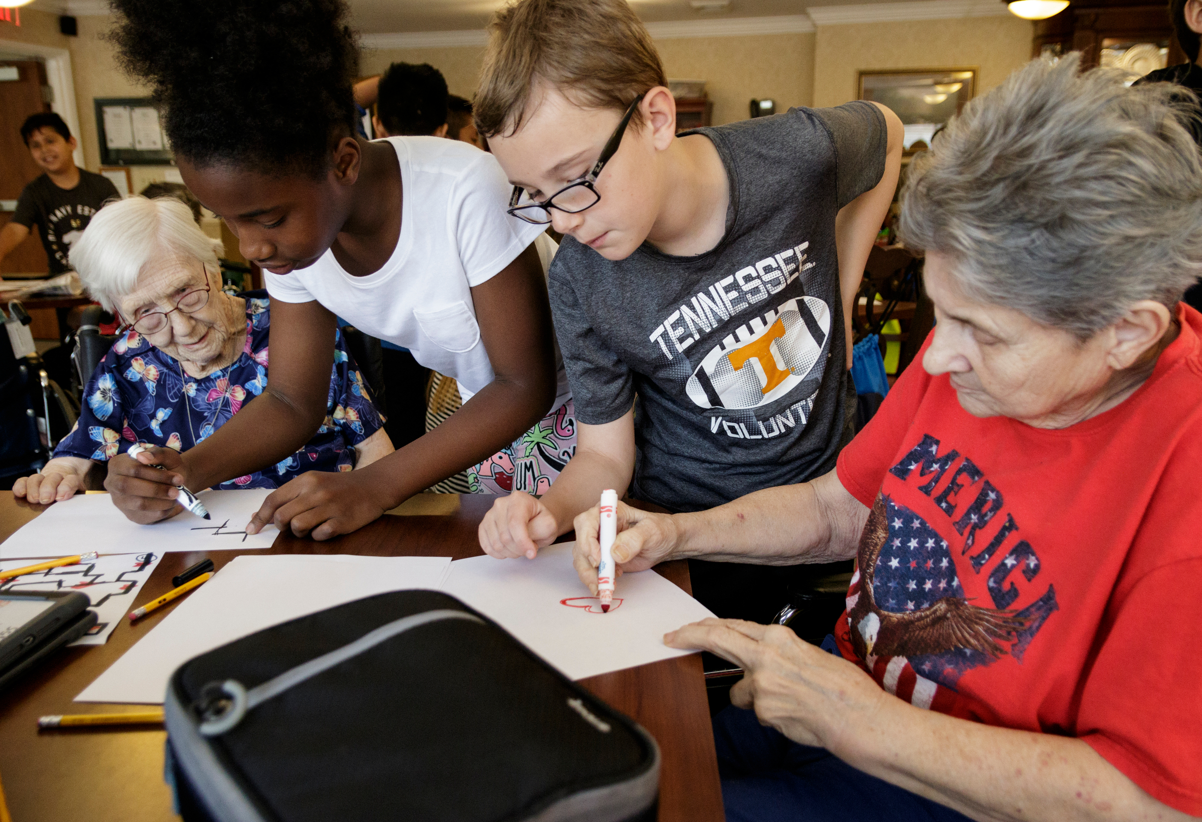 Dorothy Frank, 4th graders Amena Bennett and Peyton Alilson, and Bobbie Blackshear, from left, work together to draw lines for ozobot robots to follow at Life Care Center of Red Bank on Tuesday, May 15, 2018, in Red Bank, Tenn. Teacher Beth Wilson takes her class for active learning activities at the senior care facility.