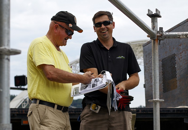 Don Sharp, left, and Mensur Ramic share a laugh while prepping a VIP area for Riverbend at Ross's Landing on Friday, June 1, 2018 in Chattanooga, Tenn. Sharp is with Friend's of the Festival and Ramic is with Chattanooga Tent Company.