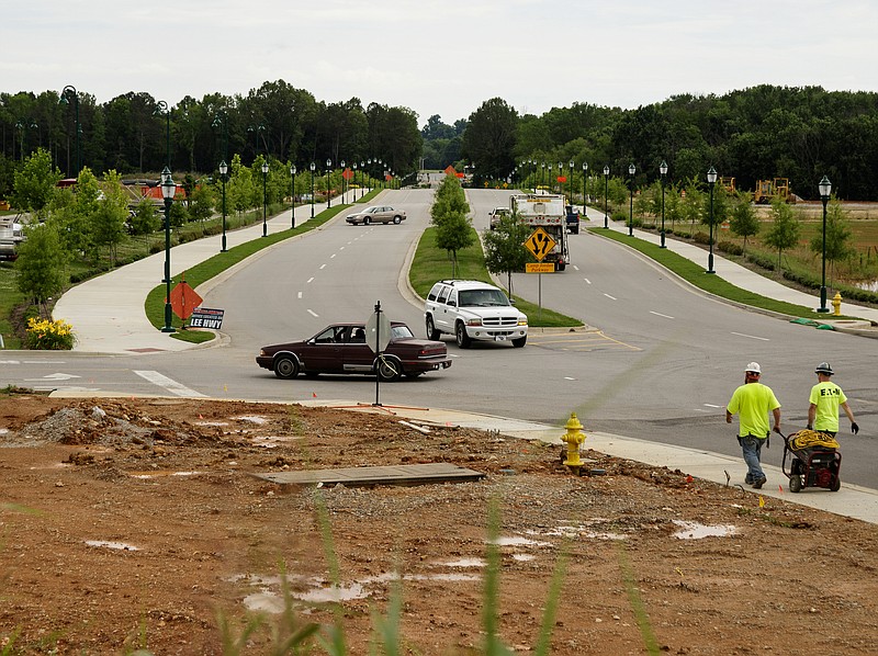 Workers set up a stop sign on the newly redesigned Camp Jordan Parkway near near Interstate 75 Exit 1 on Friday, June 1, 2018, in East Ridge, Tenn. Development which began with the construction of Bass Pro Shops has surged around the exit at the Jordan Crossing shopping center.