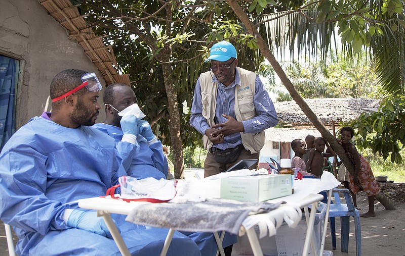 In this photo taken Friday, May 25, 2018, UNICEF staffer Jean Claude Nzengu, center, talks in late May with members of an Ebola vaccination team as they prepare to administer an experimental vaccine in an Ebola-affected community in the north-western city of Mbandaka, in Congo. (Mark Naftalin/UNICEF via AP)