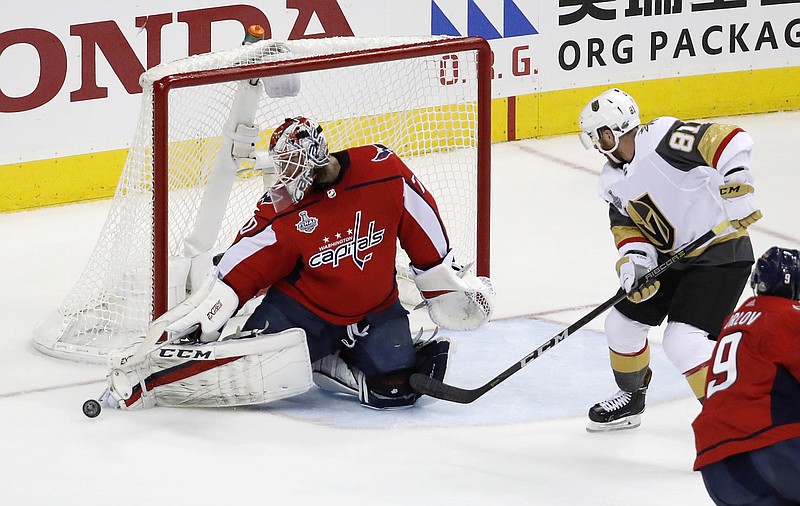 Washington Capitals goaltender Braden Holtby, left, turns the puck away as Vegas Golden Knights forward Jonathan Marchessault (81) closes in during the first period in Game 4 of the NHL hockey Stanley Cup Final, Monday, June 4, 2018, in Washington. (AP Photo/Pablo Martinez Monsivais)