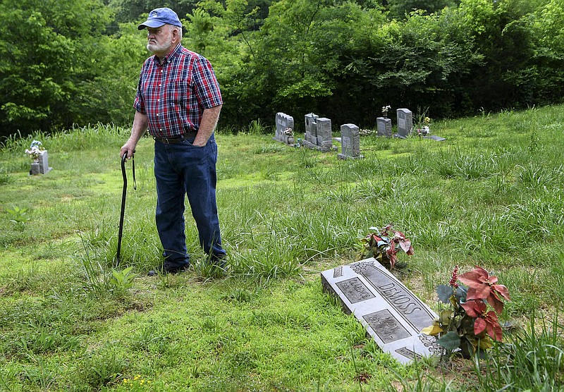 In this May 21, 2018, photo, Jim DeMoss walks around the grave of his parents and where he plans on burying his brother at the DeMoss Family Cemetery in Nashville, Tenn. Decades after crashing in Hawaii the remains of Harold DeMoss, a World War II pilot, have been positively identified. (Lacy Atkins/The Tennessean via AP)