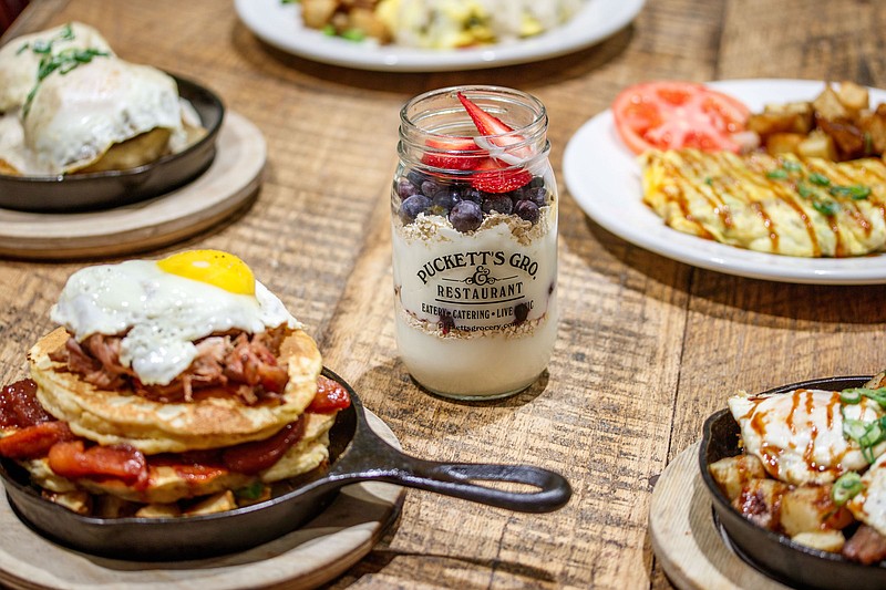 New breakfast items include the Southern Stack, left foreground, two sweet potato pancakes layered with pulled pork, fried apples, sunny-side-up egg on a bed of home fries; and Mason's Jar, vanilla Greek yogurt layered with fresh seasonal fruit and granola. (Photo: Puckett's Grocery and Restaurant)