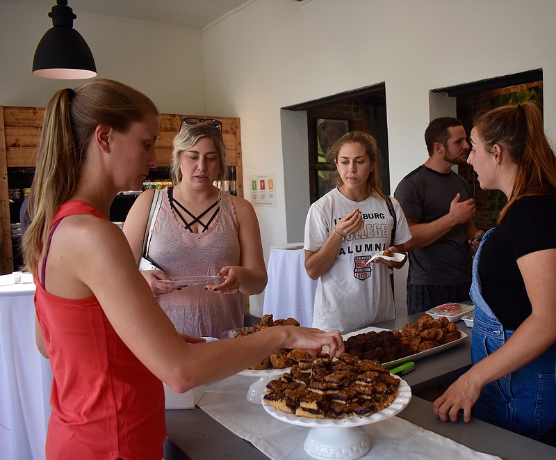 Vibrant Meals employee Allie Schrenker describes the different healthy food options to Rachel Harbarger, left, and Maggie Hart, center, at the business' grand opening on Thursday, May 31, 2018. The meal delivery service opened a storefront location at 601 Cherokee Blvd. in the North Shore.