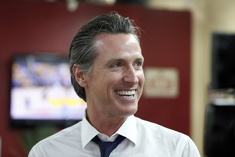 In this May 31, 2018 file photo Democratic Lt. Gov. Gavin Newsom smiles at a campaign stop at Stakely's Barber Salon in Los Angeles. Newson is expected to easily top the field in the race for govenor, but former Los Angeles Antonio Villaraigosa and state Treasurer John Chiang are among the Democrats hoping to box out Republican John Cox and make it a one-party showdown in November for the state's highest office.(AP Photo/Damian Dovarganes, File)