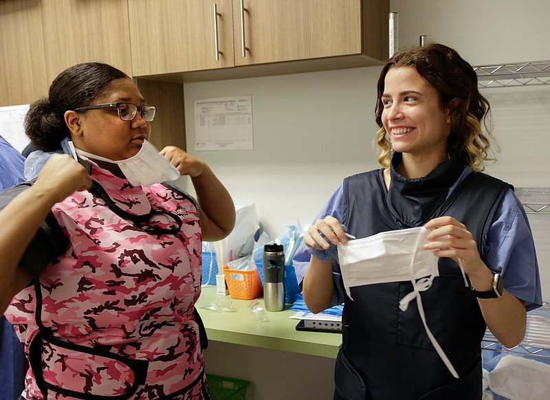 Students Khadijah Melvin, left, and Michaela Miller remove their face masks after observing a procedure at the Vascular Institute of Chattanooga on Wednesday, June 6, 2018, in Chattanooga, Tenn. The students were selected by the Chattanooga-Hamilton County Medical Society for its Youth in Medicine program to shadow physicians and healthcare providers.