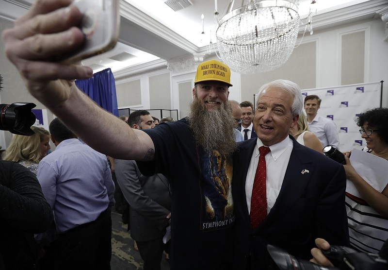 Republican gubernatorial candidate John Cox, right, stands with a supporter for a picture during a Republican election party Tuesday, June 5, 2018, in San Diego. (AP Photo/Gregory Bull)