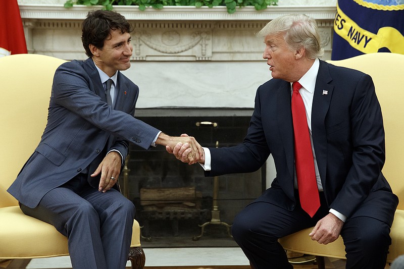 FILE- In this Oct. 11, 2017, file photo, President Donald Trump shakes hands with Canadian Prime Minister Justin Trudeau in the Oval Office of the White House. When Trump visits Canada this week there's speculation he could walk out of meetings with allies furious over his belligerent trade policies. Trudeau has said he finds it "insulting" that Trump considers Canadian imports a threat, saying that is not how allies who fought side-by-side in World War II, Korea and Afghanistan should treat one another. (AP Photo/Evan Vucci, File)