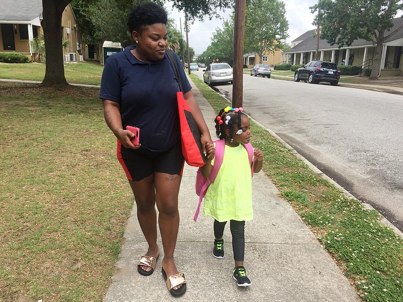 In this May 17, 2018 photo, Shannon Brown, 29, walks with her four-year-old daughter, Sai-Mya, in Charleston, S.C.  Brown lives in public housing and could face a steep increase under a HUD proposal that would raise rents for millions of low-income individuals and families. (AP Photo/Juliet Linderman)