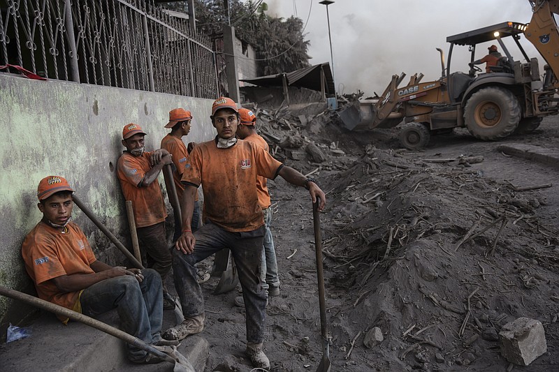 Rescue workers gather in the disaster zone covered in volcanic ash near the Volcan de Fuego, or "Volcano of Fire, in the El Rodeo hamlet of Escuintla, Guatemala, Wednesday, June 6, 2018. Firefighters said the chance of finding anyone alive amid the still-steaming terrain was practically nonexistent 72 hours after Sunday's volcanic explosion. (AP Photo/Rodrigo Abd)

