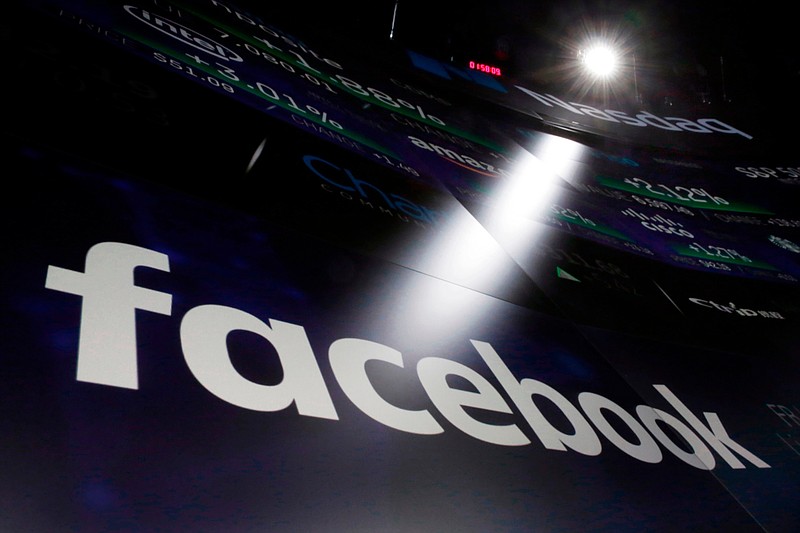 In this March 29, 2018, file photo the logo for Facebook appears on screens at the Nasdaq MarketSite in New York's Times Square. Facebook says a software bug made some private posts public for as many as 14 million users for several days in May. (AP Photo/Richard Drew, File)