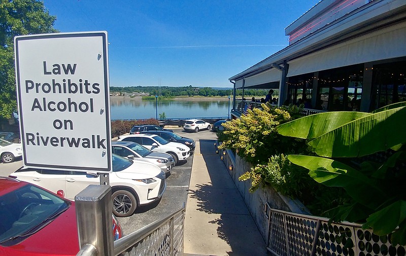 A sign prohibiting alcoholic beverages on the Riverwalk can be seen by the Boathouse restaurant.