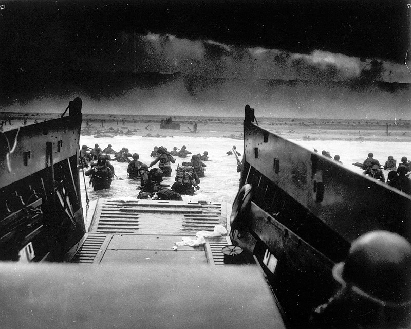 While under attack of heavy machine gun fire from the German coastal defense forces, these American soldiers wade ashore off the ramp of a U.S. Coast Guard landing craft on June 6, 1944, during the Allied landing operations at the Normandy. (AP file photo)