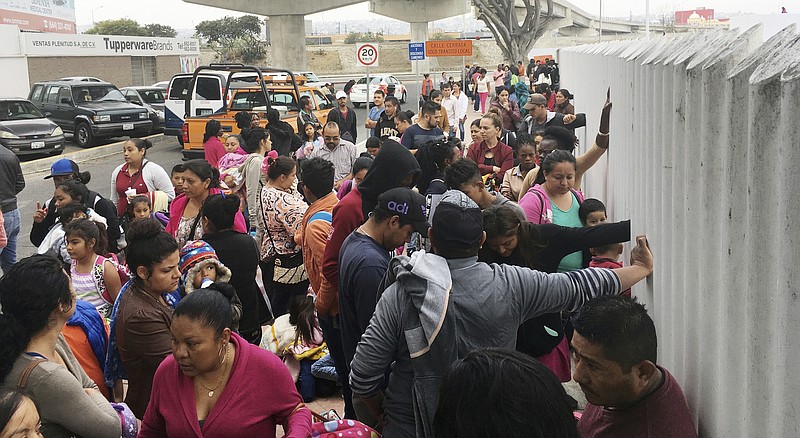 In this Monday, June 4, 2018 photo, people seeking political asylum in the United States line up to be interviewed in Tijuana, Mexico, just across the U.S. border south of San Diego. The Trump administration's fighting words for asylum seekers don't appear to be having much impact at U.S. border crossings with Mexico. Lines keep growing, so much that U.S. authorities can't take them all at once. (AP Photo/Elliot Spagat)