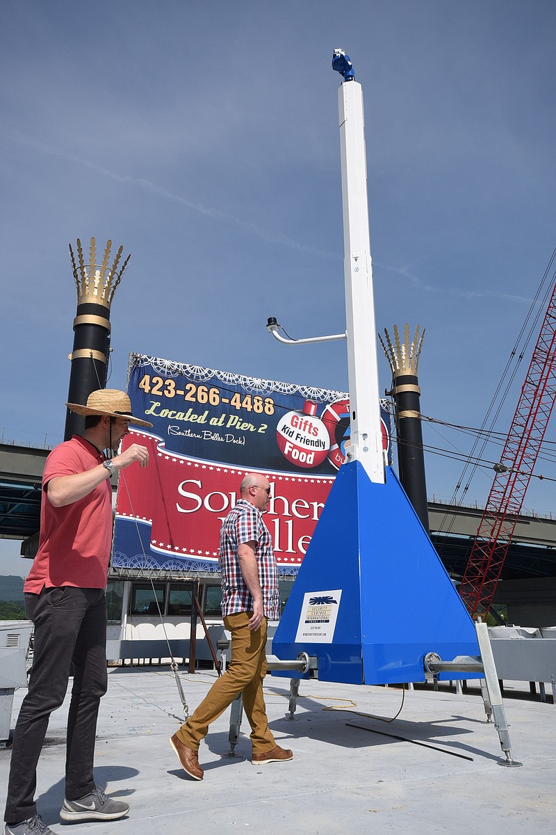 Conor Aucoin, left, and Tyler McGehee walk around surveillance equipment set atop the welcome barge at the Southern Belle at the outset of the Riverbend Festival on Friday morning.