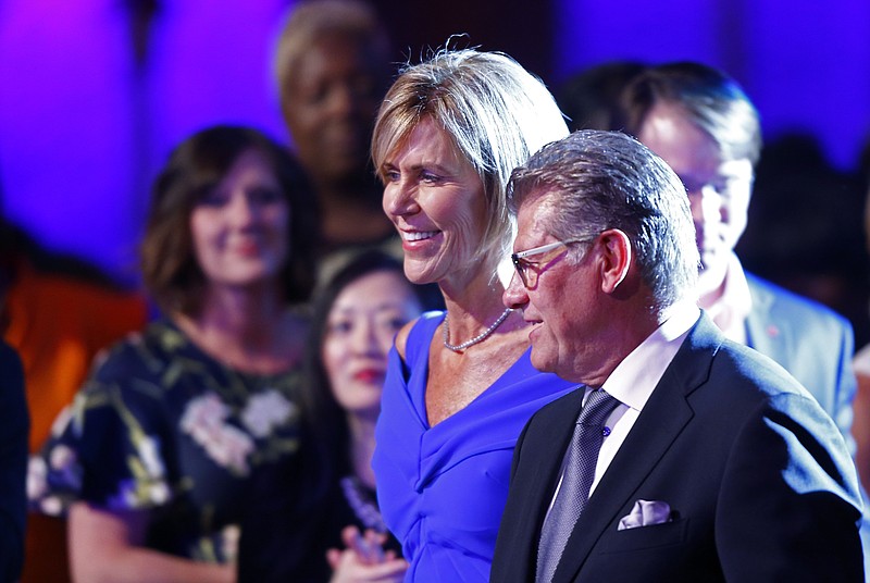 Connecticut assistant coach Chris Dailey, is escorted by coach Geno Auriemma during induction ceremonies at the Women's Basketball Hall of Fame on Saturday, June 9, 2018, in Knoxville, Tenn. (AP Photo/Wade Payne)