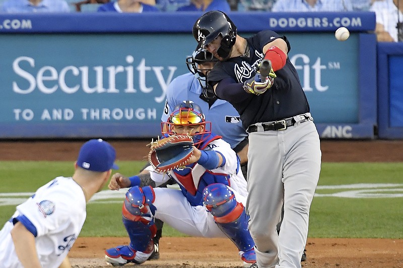Atlanta Braves' Tyler Flowers, right, hits a two RBI double as Los Angeles Dodgers starting pitcher Alex Wood, left, watches along with catcher Yasmani Grandal, second from left, and home plate umpire Angel Hernandez during the third inning of a baseball game, Saturday, June 9, 2018, in Los Angeles. (AP Photo/Mark J. Terrill)