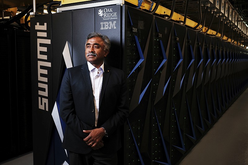 Thomas Zacharia, director of the Oak Ridge National Laboratory, with Summit, the world's fastest supercomputer, in Oak Ridge, Tenn. last week. Summit can do mathematical calculations at the rate of 200 quadrillion per second, or 200 petaflops. If a person did one calculation a second, she would have to live for more than 63 billion years to match what the machine can do in a second. (Shawn Poynter/The New York Times)