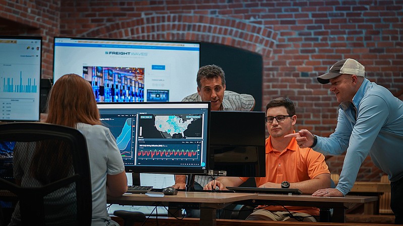 Contributed photo by FreightWaves / FreightWaves officials go over data at the company's Chattanooga headquarters. From left are Alexandra Quevedo, market analyst; Vice President John Bowes, Controller Andrew Mayfield, and CEO Craig Fuller.