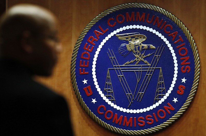 FILE- This Dec. 14, 2017, file photo, shows the seal of the Federal Communications Commission (FCC) before a meeting in Washington.