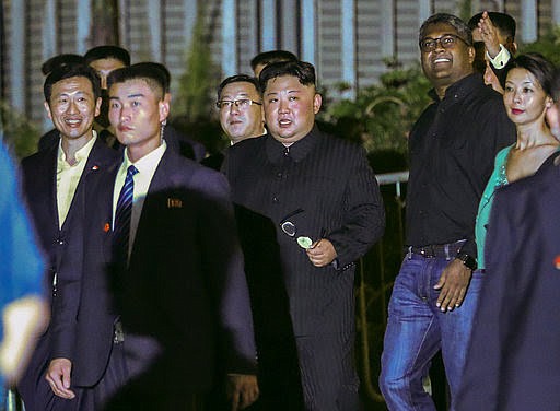 North Korea leader Kim Jong Un, center, is escorted by his security delegation as he visits Marina Bay in Singapore, Monday, June 11, 2018, ahead of Kim's summit with U.S. President Donald Trump. (AP Photo/Yong Teck Lim)

