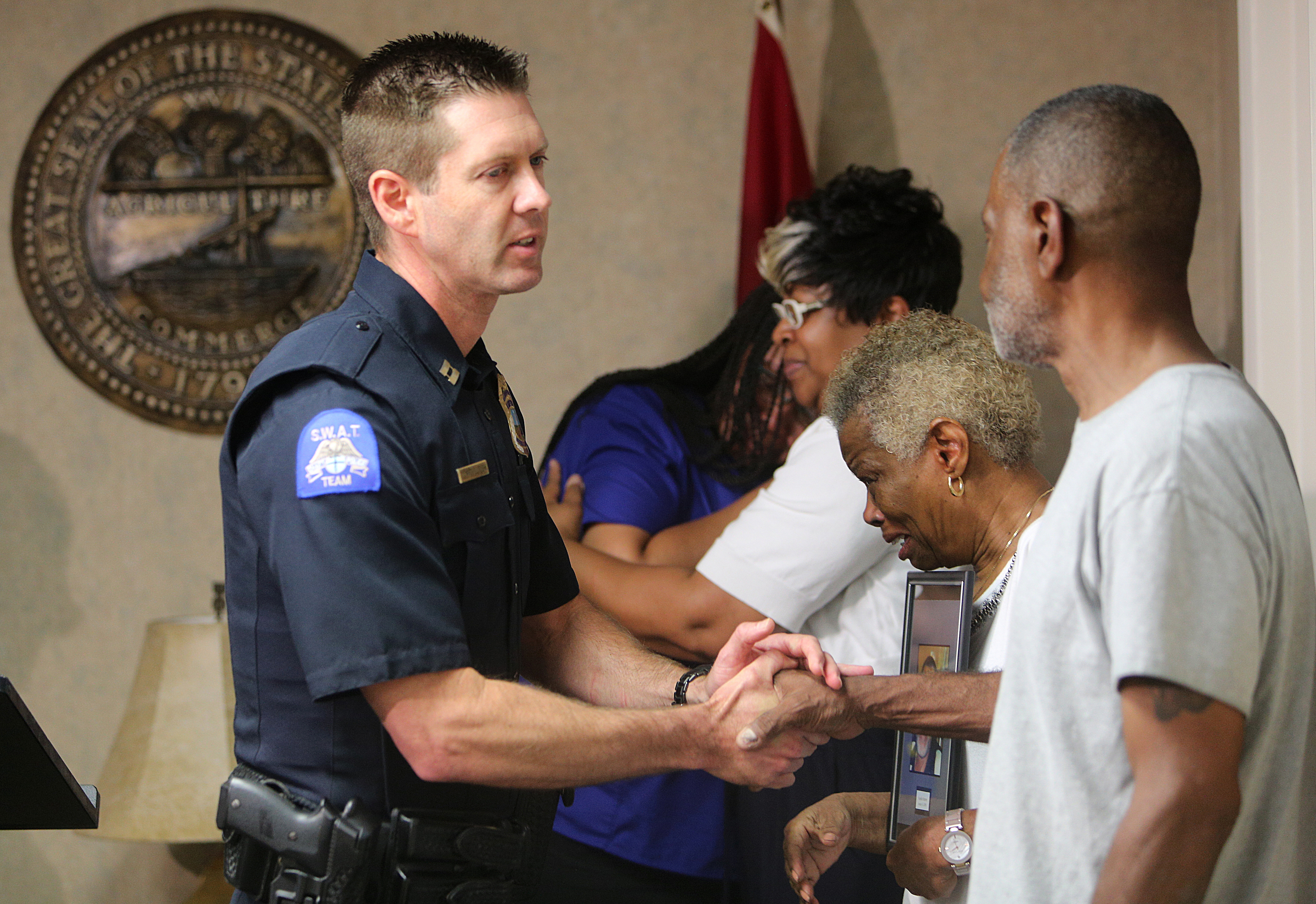 Chattanooga Police Captain Zachary McCullough shakes the hand of Preston Bonner, the son of Franklin Augustus ҋookieӠBonner, during a press conference at the Newell Towers Tuesday, June 12, 2018 in Chattanooga, Tennessee. The press conference was held to let the public know the Hamilton County Grand Jury returned indictments of felony murder robbery and especially aggravated robbery against Mallory Aunte Vaughn in the 2009 homicide of Franklin Bonner, and they are seeking the help of the public to find Vaughn.