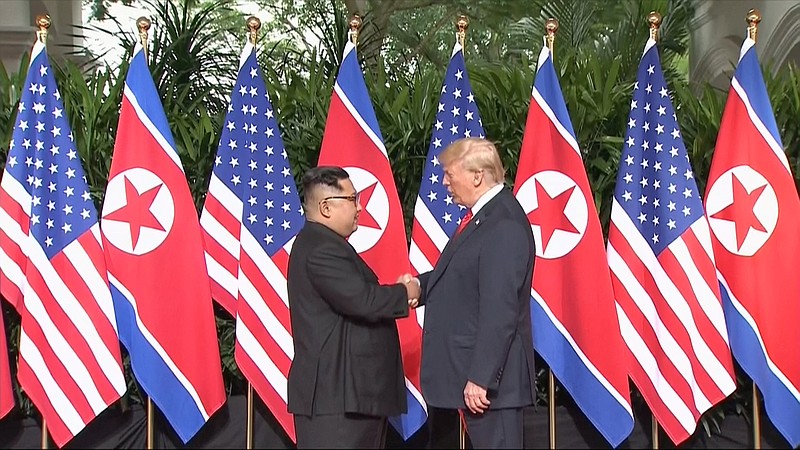 U.S. President Donald Trump and North Korean leader Kim Jong Un shake hands ahead of their meeting at Capella Hotel in Singapore Tuesday.