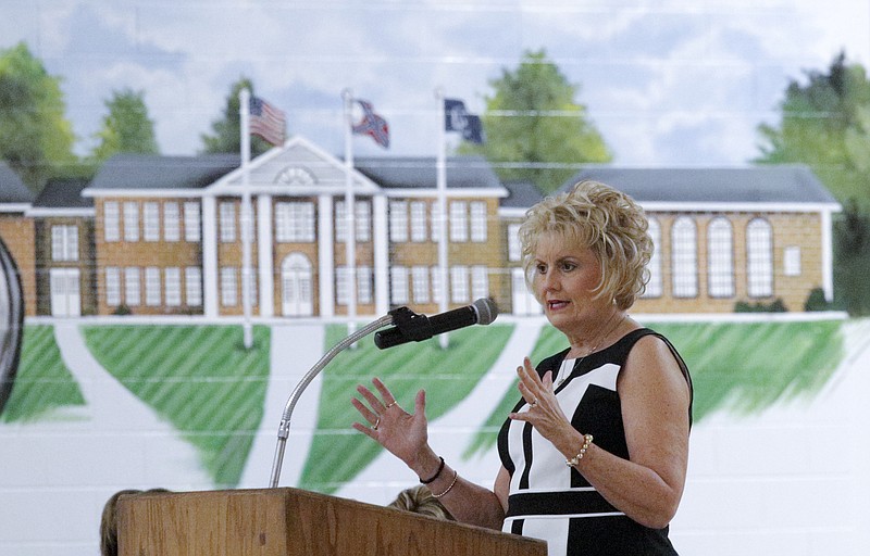 School superintendent Melody Day, seen in front of a mural of the existing Gordon Lee building, speaks during a Chickamauga City School Board meeting held Tuesday, June 2, 2015, at Gordon Lee High School in Chickamauga, Ga., to inform the public about plans for two 1930s-era buildings on campus. The board's proposal for solving problems related to the age of the buildings includes building new historically-accurate buildings in front of the old ones before demolishing them.