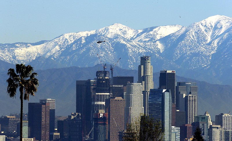 File - In this Jan. 12, 2016 file photo, the snow-capped San Gabriel Mountains stand as a backdrop to the downtown Los Angeles skyline.