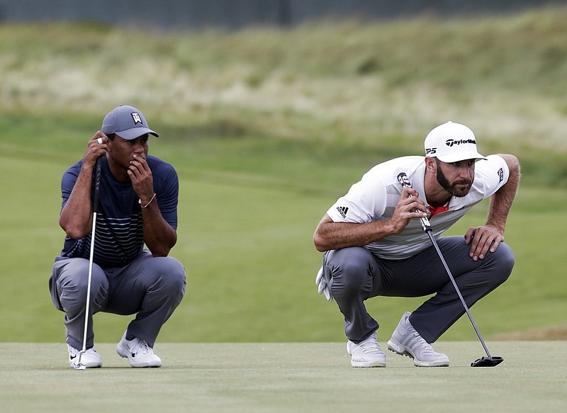 Tiger Woods, left, and Dustin Johnson line up their putts on the 16th green at Shinnecock Hills Golf Club during Thursday's first round of the U.S. Open in Southampton, N.Y. Woods struggled to an 8-over-par 78, but Johnson shot a 69 and shared the lead as one of just four golfers under par.