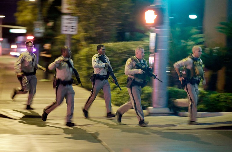 FILE - In this Oct. 1, 2017, file photo, police run toward the scene of a shooting near the Mandalay Bay resort and casino on the Las Vegas Strip in Las Vegas. 