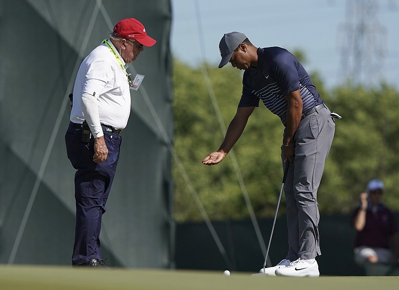 Tiger Woods, right, talks with an official on the tenth green after the wind moved his ball after he addressed it during the first round of the U.S. Open Golf Championship, Thursday, June 14, 2018, in Southampton, N.Y. (AP Photo/Carolyn Kaster)