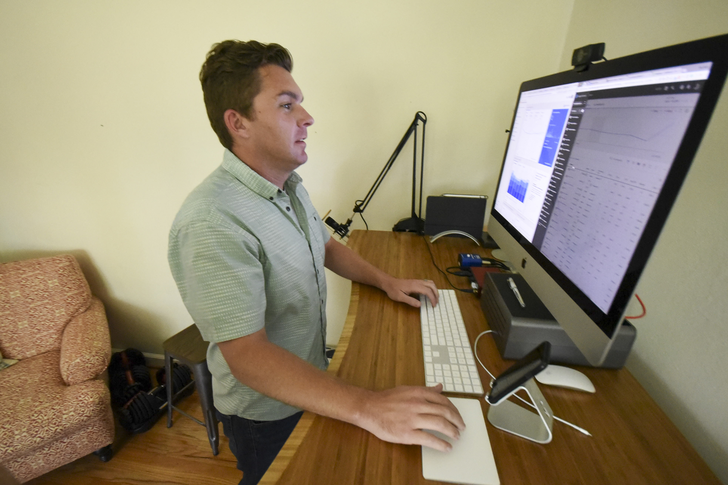Rob Bettis stands at his desk and performs his marketing work from home in Stuart Heights.